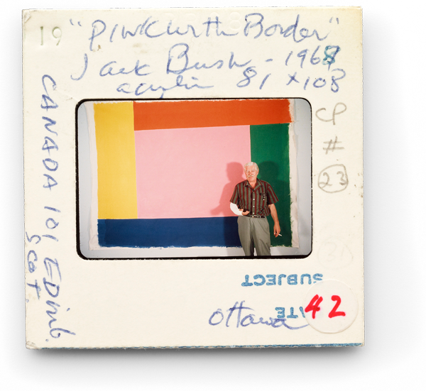 Jack Bush standing in front of his painting “Pink With Border” (1967)